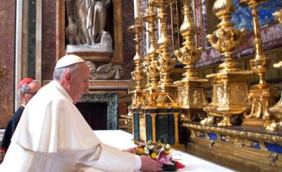 Pope Francis puts flowers on the altar inside St. Mary Major Basilica ~ Photo by AP/L'Osservatore Romano